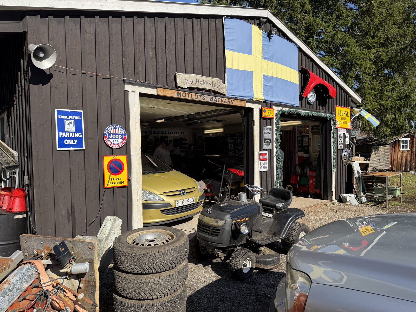 Sidoplanen med 'Old Farts Garage'-skyltar och uthus