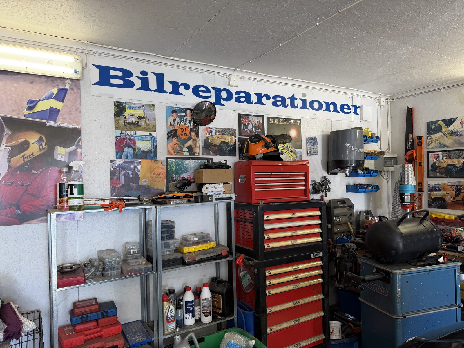 Hörnan med 'Bilreparationer'-skylt, verktygsvagn och offroad-bilder
